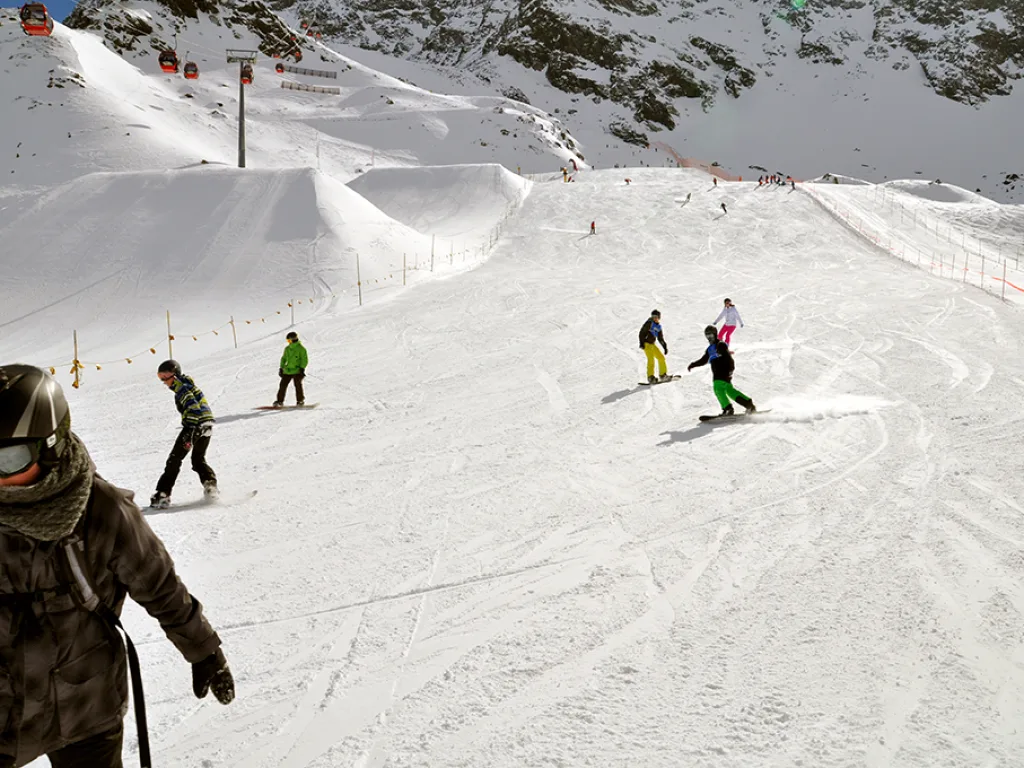 Snowboarder in tiefer Hocke auf der Piste.